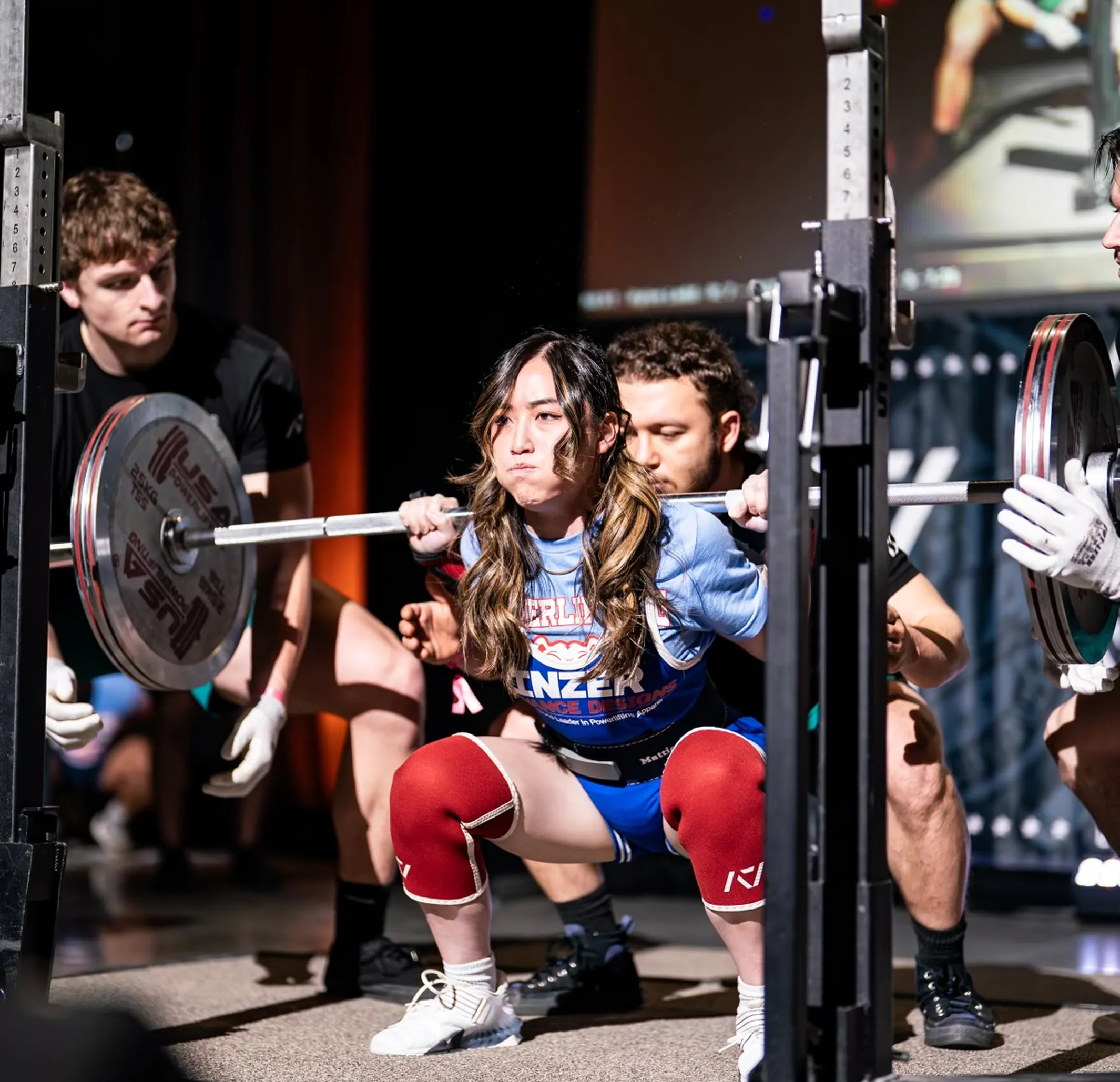 A lady squating a bar